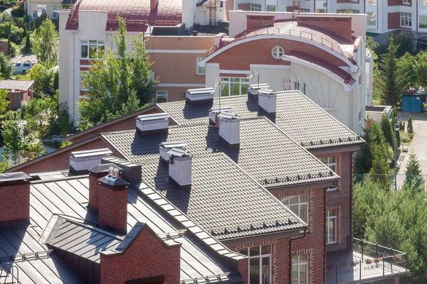 Üst kattaki binanın çatısı. Karışık kullanımlı, çoklu aile yerleşim bölgesi. Güneşli bir gün.