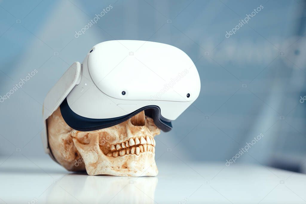 VR helmet put on a human skull the harm of virtual reality to human health.