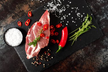 Yangında pişirmek için baharatlı çiğ domuz eti ya da karanlık bir taşta fırın.