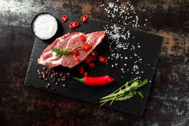 Yangında pişirmek için baharatlı çiğ domuz eti ya da karanlık bir taşta fırın.