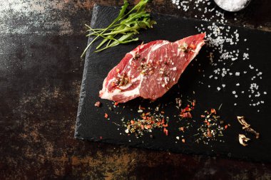 Yangında pişirmek için baharatlı çiğ domuz eti ya da karanlık bir taşta fırın.