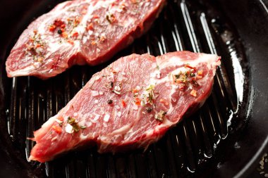 Yangında pişirmek için baharatlı çiğ domuz eti ya da karanlık bir taşta fırın.