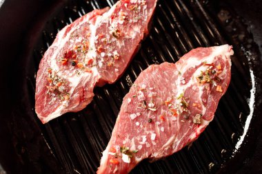 Yangında pişirmek için baharatlı çiğ domuz eti ya da karanlık bir taşta fırın.