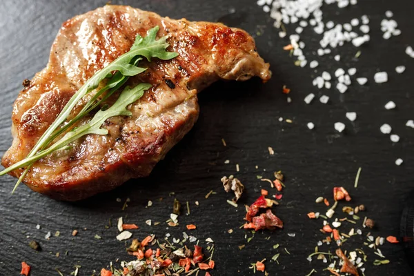 Koyu taşlı arka planda baharatlı kızarmış domuz eti.