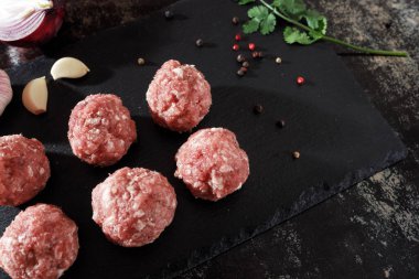 Koyu arkaplanda çiğ domuz pirzolası.