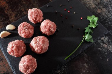 Koyu arkaplanda çiğ domuz pirzolası.