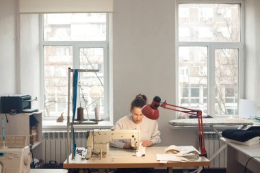 Genç bayan terzi atölyesinde terzilik yaparken