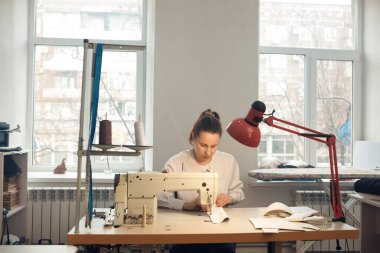 Genç bayan terzi atölyesinde terzilik yaparken
