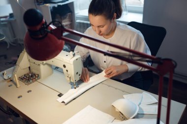 Genç bayan terzi atölyesinde terzilik yaparken