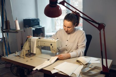 Genç bayan terzi atölyesinde terzilik yaparken