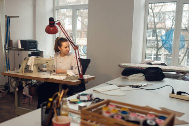 Genç bayan terzi atölyesinde terzilik yaparken