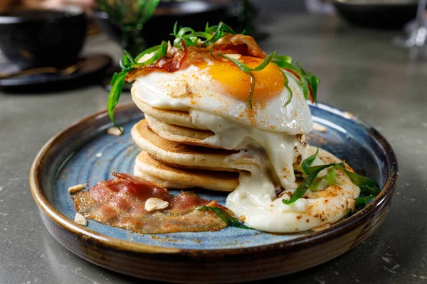 Pancakes with bacon, fried eggs and melted cheese