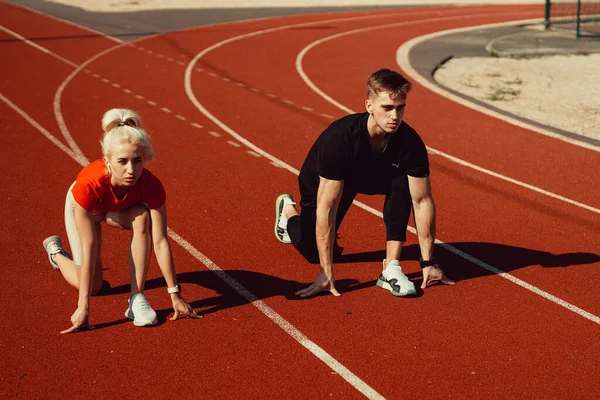 Güzel sarışın ve erkek koşmaya hazırlanıyor.