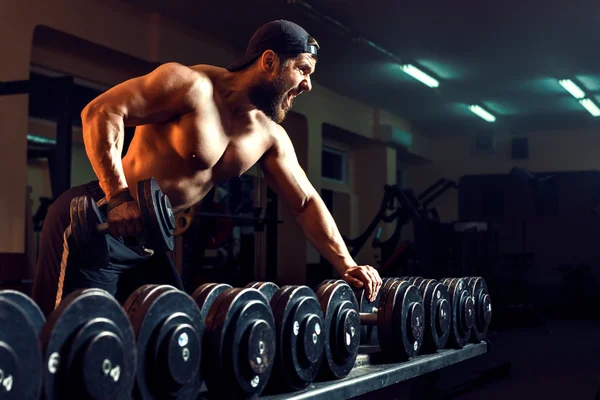 Muscular male bodybuilder working out in gym — Stock Photo, Image