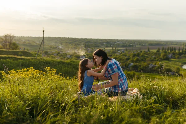 Kleines süßes Mädchen mit ihrer Mutter bei Sonnenuntergang — Stockfoto