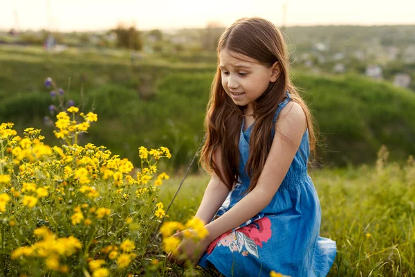 Κοριτσάκι μυρίζοντας ένα κίτρινο λουλούδι — Φωτογραφία Αρχείου