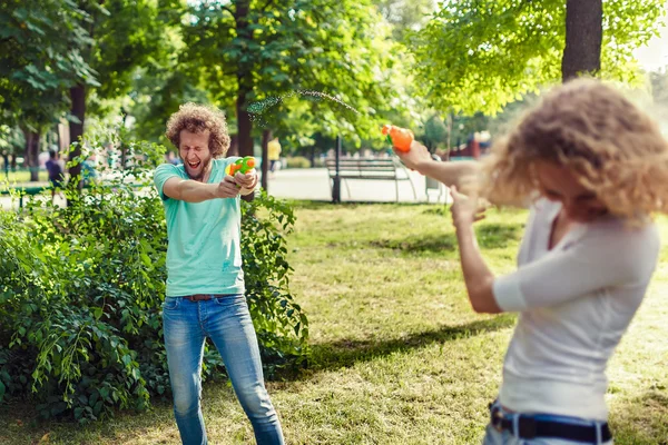 Друзья играют с водяным пистолетом — стоковое фото