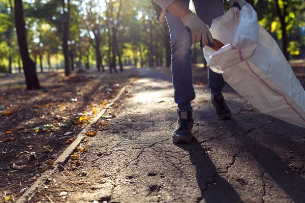 Junger Mann sammelt Müll auf — Stockfoto