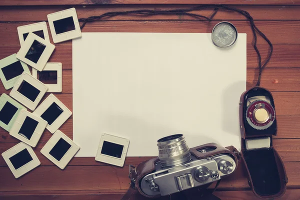 Retro camera and some old photos on wooden table — Stock Photo, Image