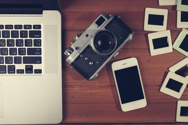 Retro camera and some old photos on wooden table. — Stock Photo, Image