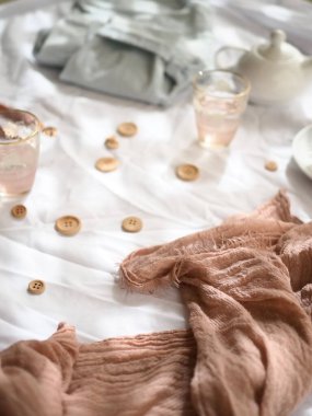 Pembe atkı, ahşap düğmeler ve beyaz arka planda kot pantolon..