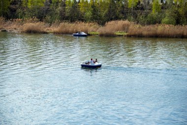 İnsanlar ayaklarıyla çalışan bir katamaran su eğlence parkına biniyorlar.