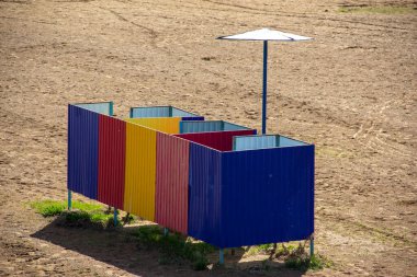 Renkli kabinler yaz göleti kum şemsiyeleri güneş kremleri sıcak su eğlencesi