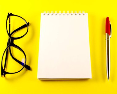 Not defteri, defter, kalem, gözlük, sarı arkaplan, üst görünüm kopyalama alanı