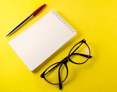 Not defteri, defter, kalem, gözlük, sarı arkaplan, üst görünüm kopyalama alanı