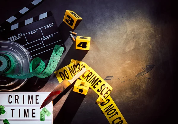 White sign titled crime time next to film reel and yellow crime scene tape with black and rolls of tickets