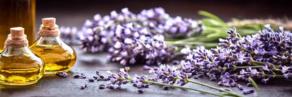 アロマセラピー 代替医療 香水のためのエッセンシャルオイルのフラコンとパノラマバナーや新鮮な紫色のラベンダーのヘッダー ストック画像