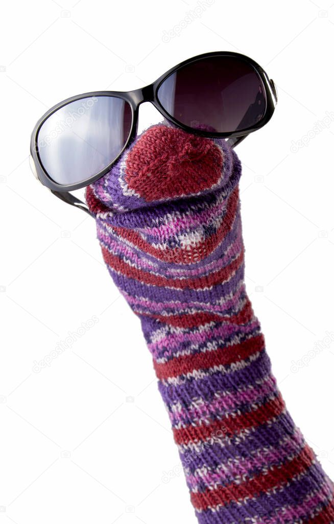 Colorful striped sock puppet with sunglasses isolated on white background
