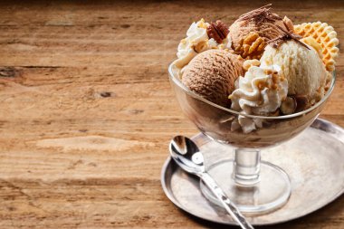 Lezzetli çikolata ve vanilyalı dondurma büyük cam kasede kaşıkla. Kopyalama alanı içerir.