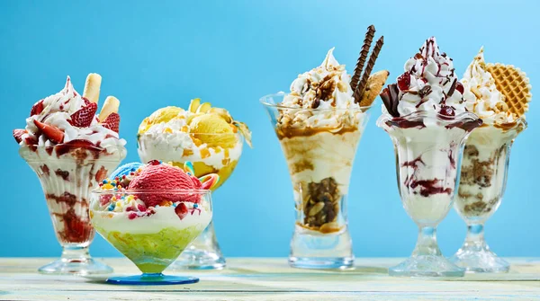 Krásné Zmrzlinové Dezerty Odrůda Různých Skleněných Miskách Proti Modrému Backgorund — Stock fotografie