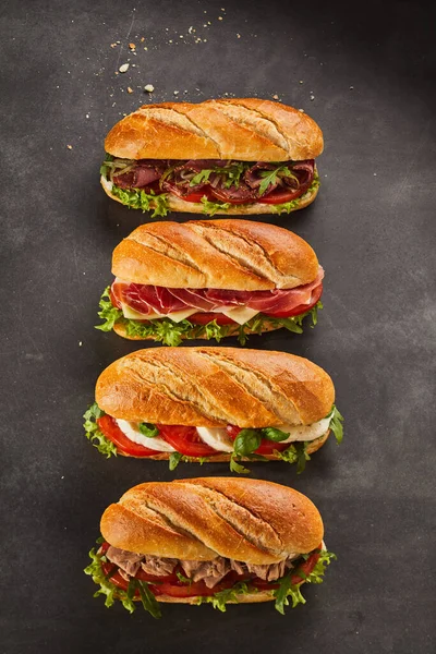 Conjunto Cuatro Sándwiches Completos Rellenos Lonchas Carne Verduras Sobre Fondo — Foto de Stock