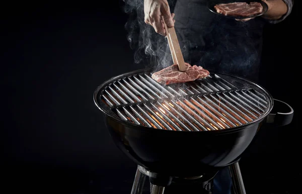 Man Placing Raw Meat Hot Barbecue Grill Using Pair Wooden — Stock Photo, Image