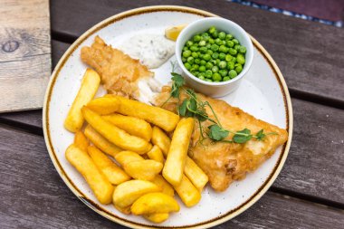 Fish and Chips 'in en iyi manzarası İngiltere' de bezelyelerle servis ediliyor.