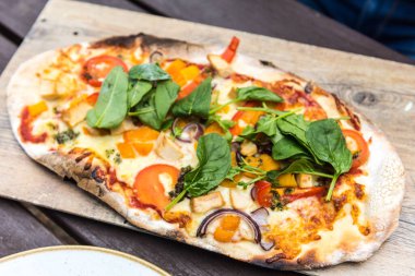 Peynirli, soğanlı, ıspanaklı, domatesli ve tavuklu taze pizza.