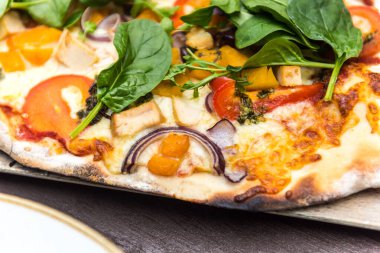 Peynirli, soğanlı, ıspanaklı, domatesli ve tavuklu taze pizza.