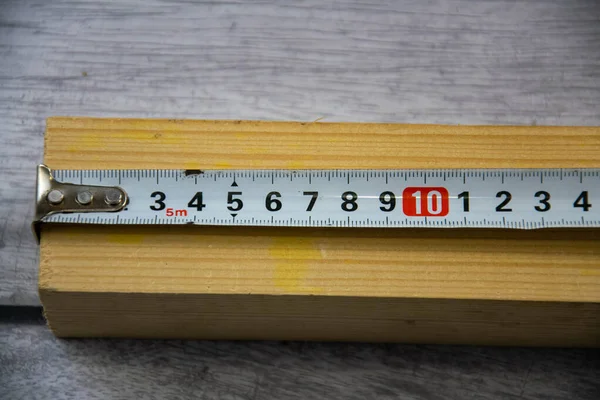 Pomiar z taśmą pomiarową z drewnianego pręta. — Zdjęcie stockowe