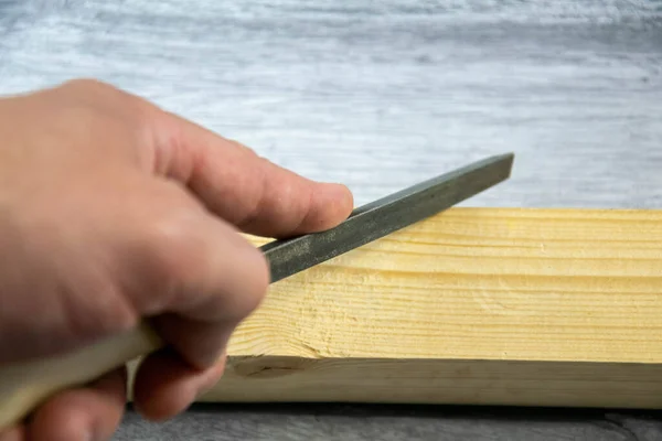 A locksmiths tool-a file, in the hand on a gray background. — Stock Photo, Image