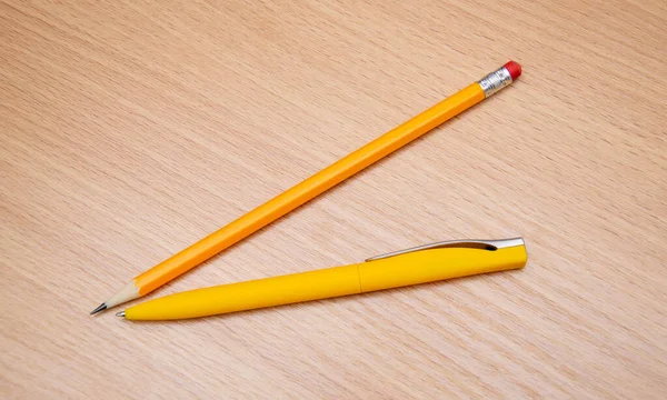 Žlutá tužka a pero na stůl. — Stock fotografie