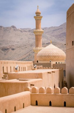 Minare, kubbe ve ortaçağ Arap kalesi Nizwa, Umman. Arap çöl şehrinde sıcak bir gün. Ortadoğu askeri mimarisi. Arap Kalesi.