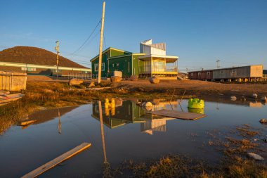 Qikiqtarjuaq, Broughton Adası, Nunavut, Kanada 'da altın saat. Kanada 'daki parklar su yüzeyine yansıyor. Uzak kuzeyde yerleşim yeri. Kutup bölgesi. Kuzey..