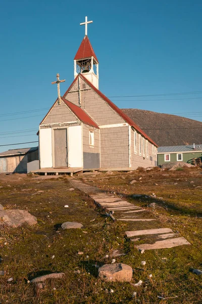 Small anglican church in the Canadian arctic in the golden hour. St. Michael and All Angels Church in Inuit community of Qikiqtarjuaq, Broughton Island, Nunavut. The north.
