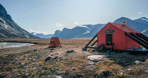 Emergency shelter in arctic wilderness with a backpack in front of it . Sunny day in Akshayuk Pass valley, Auyuittuq National Park, Baffin Island, Nunavut, Canada. The north.