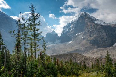 Kanada Kayalıklarında Lefroy Tepesi parçalı bulutlu bir günde güneş ışığıyla aydınlatılıyor. Lefroy Dağı, Banff Ulusal Parkı, Kanada 'daki Six Glaciers Ovası' ndan görüldü. Kanada Kayalıkları 'nı gezmek ve keşfetmek.