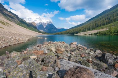 Kanada Banff Ulusal Parkı 'ndaki teselli gölleri üzerinde kısmen güneşli bir gün. Yazın Kanada Kayalıkları 'nın muhteşem manzarası. Yüksek tepeler arasında Kanada gölleri ve ormanları.