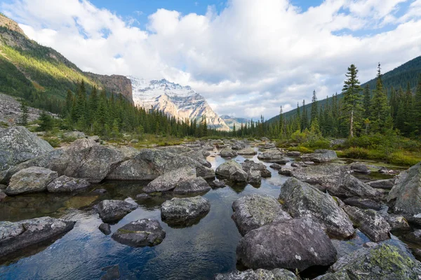 Kanada Banff Ulusal Parkı 'ndaki teselli gölleri üzerinde kısmen güneşli bir gün. Yazın Kanada Kayalıkları 'nın muhteşem manzarası. Yüksek tepeler arasında Kanada gölleri ve ormanları.