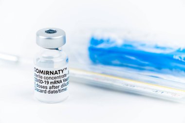 Celadna, Çek Cumhuriyeti - 05.30.2021: Pfizer 'ın Comirnaty aşısı ampulü, mavi yüz maskesi ve tıbbi termometresi ile hayat